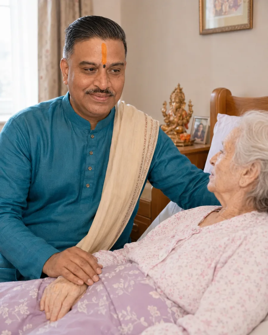 A Hindu priest seated at the bedside of an elderly person resting at home, a hand resting gently on the bedcovers